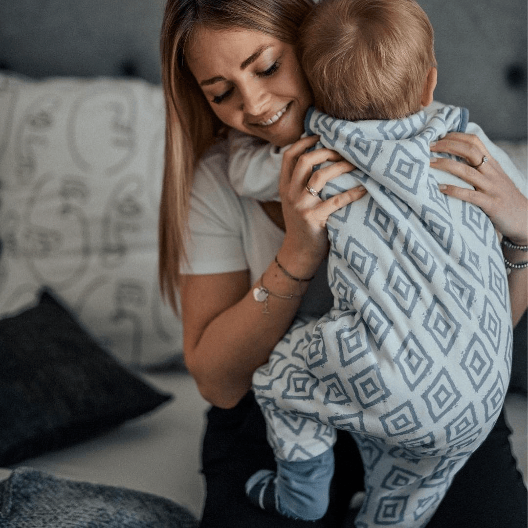 Baby im Schlafsack mit Füßen mit Mama